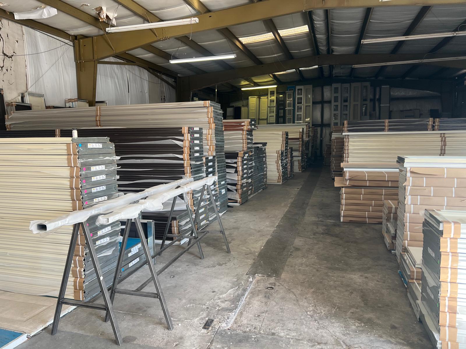 Warehouse interior stacked with garage door panels of various colors